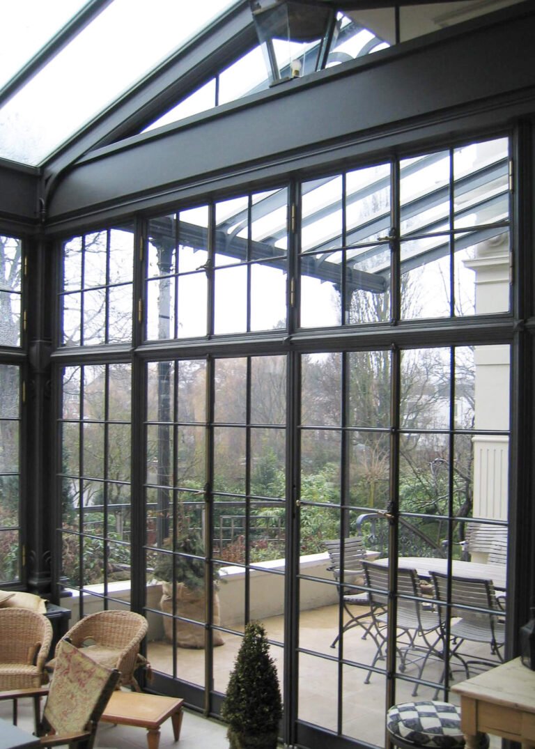 Lichtdurchfluteter Wintergarten mit Ausblick in den Garten gefertigt von der Schmiede Lehmann in Hamburg