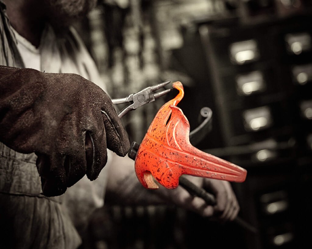 Nahaufnahme von einem glühenden Stahlornament, welches mit der Zange bearbeitet wird in der Schmiede Lehmann in Hamburg.