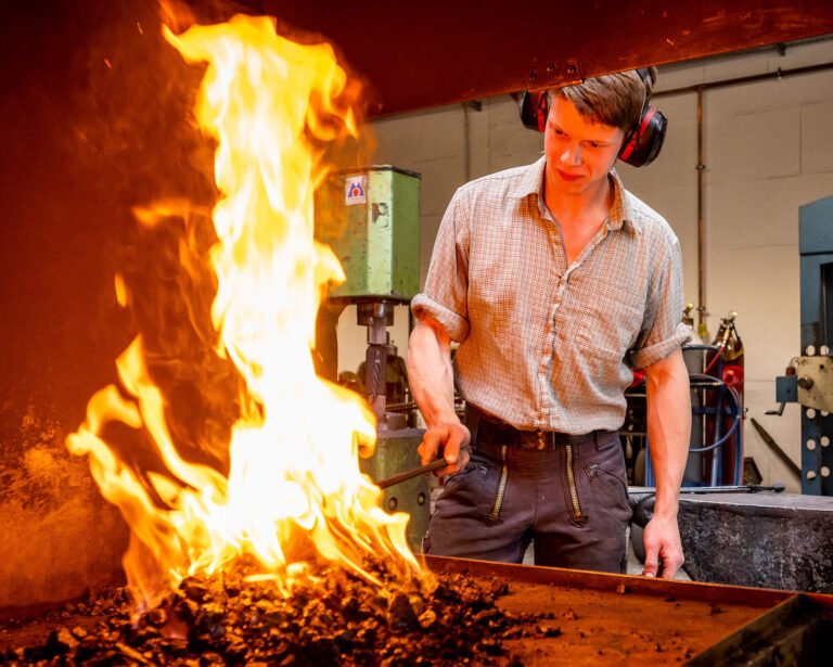 Feuer in einer Schmiede, Lehrling Tim bei der Arbeit in der Schmiede Lehmann in Hamburg